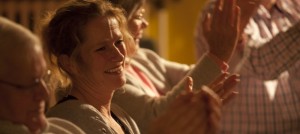 Woman in audience smiling and clapping